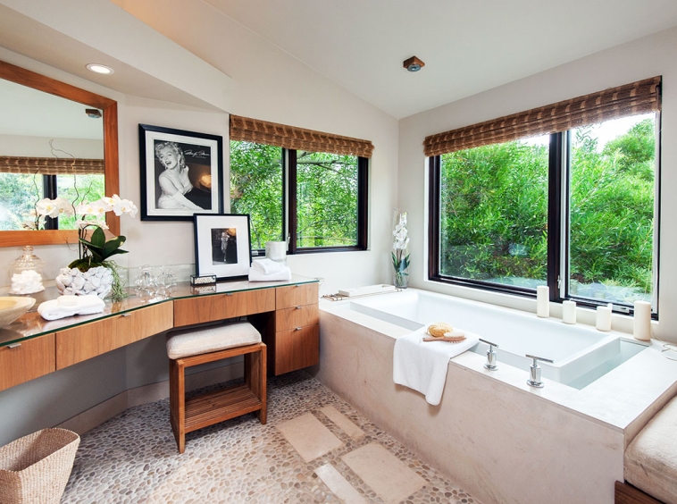A bathroom with a tub, sink and vanity.