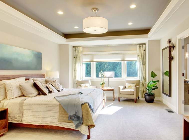 A bedroom with a bed, chair and window.