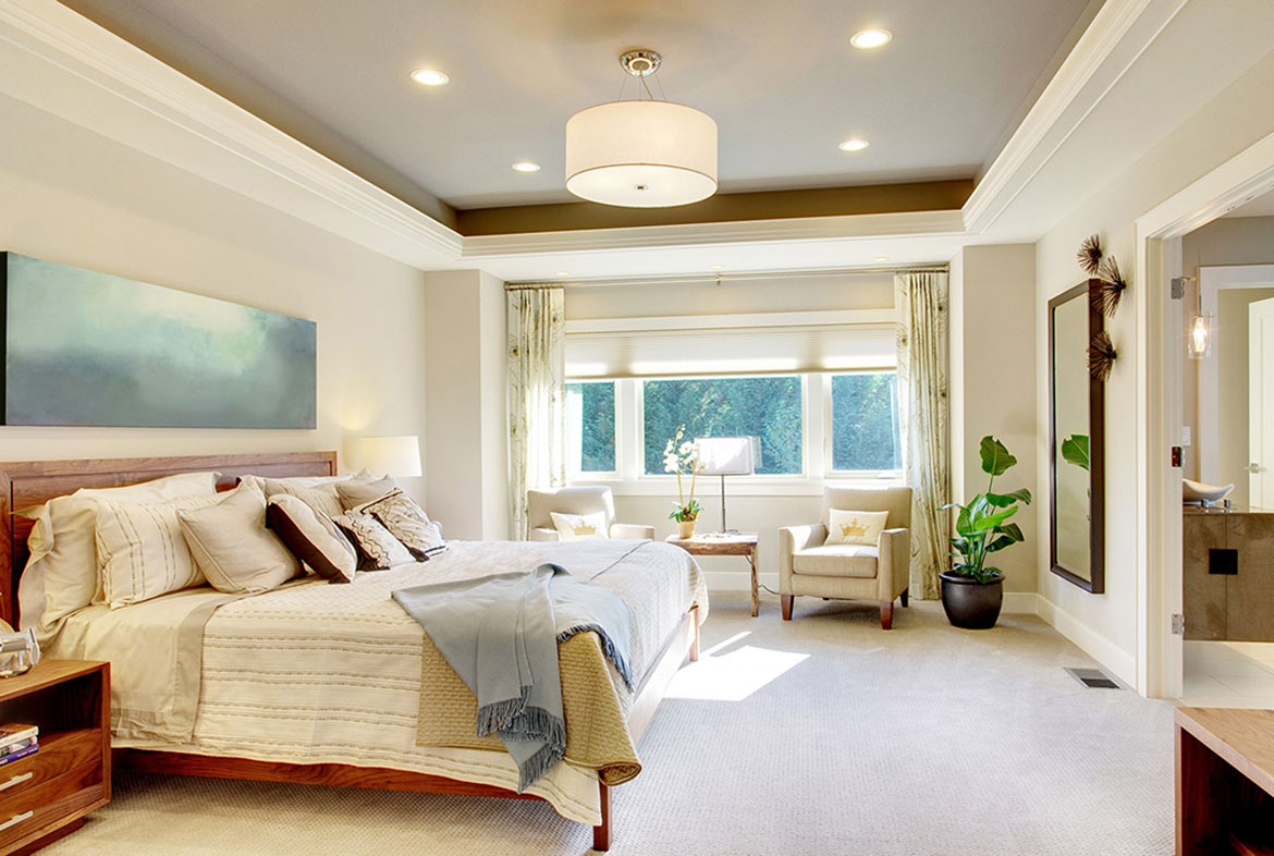 A bedroom with a bed, chair and window.