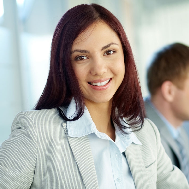 A woman in a suit and tie smiling for the camera.
