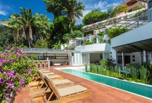 A pool with chairs and a bench near it