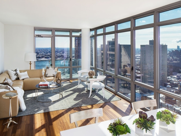 A living room with large windows and a view of the city.