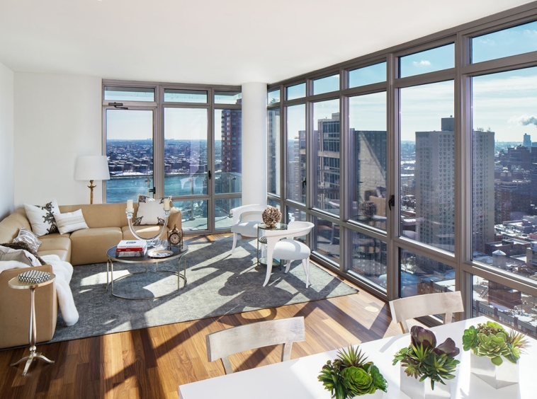 A living room with large windows and a view of the city.