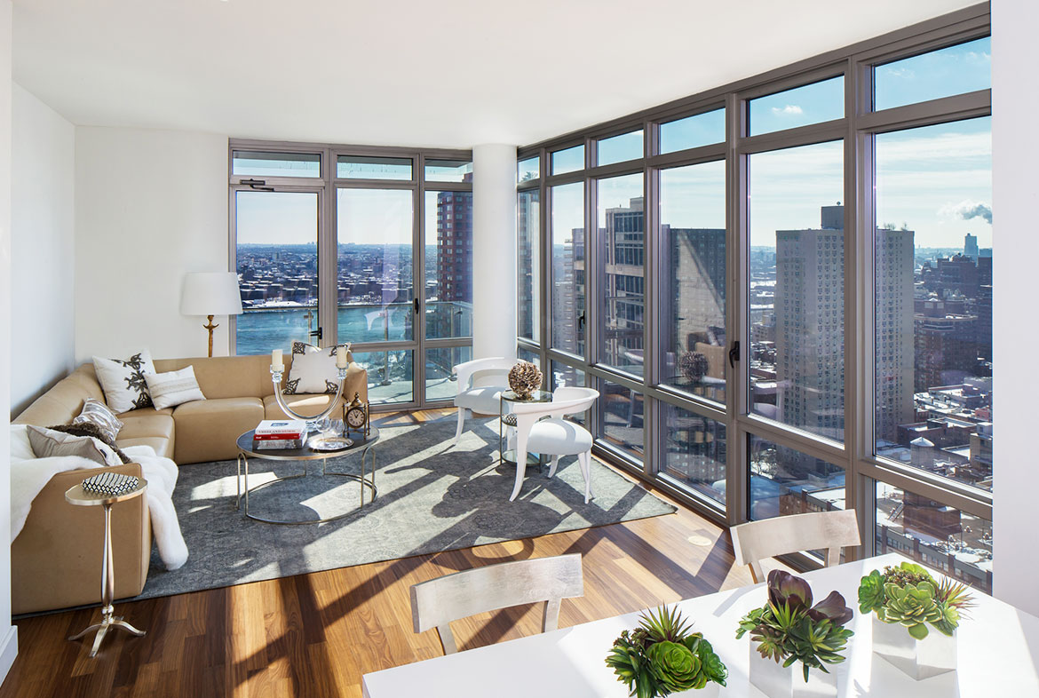A living room with large windows and a view of the city.