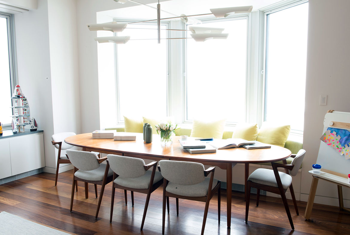 A dining room table with chairs and pillows.